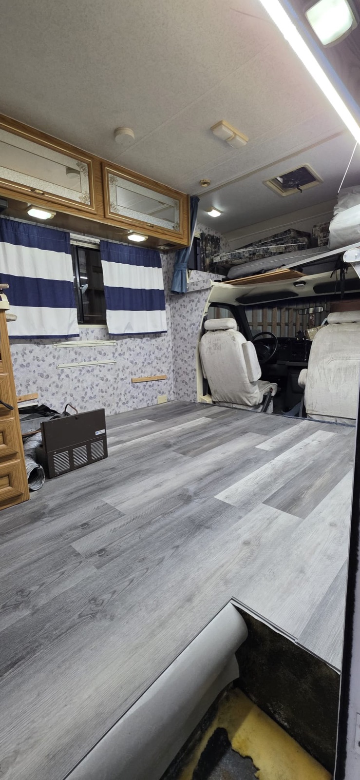 Renovated RV interior with new grey vinyl-plank flooring